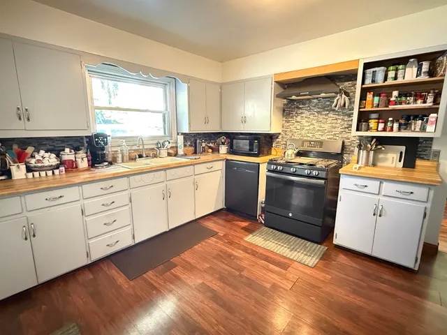 a kitchen with stainless steel appliances granite countertop a stove sink and cabinets