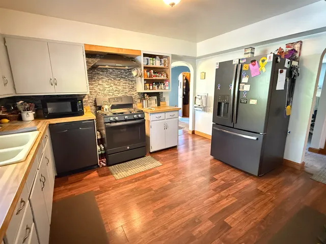 a kitchen with stainless steel appliances granite countertop a refrigerator stove and sink