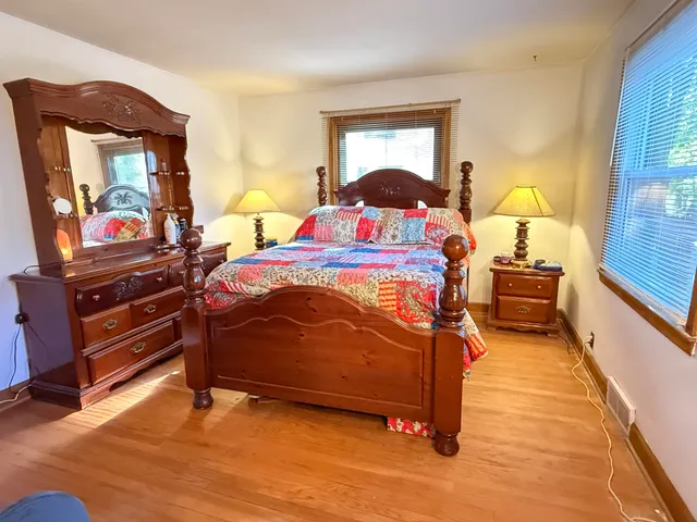 a bedroom with a bed and a flat tv screen on dresser
