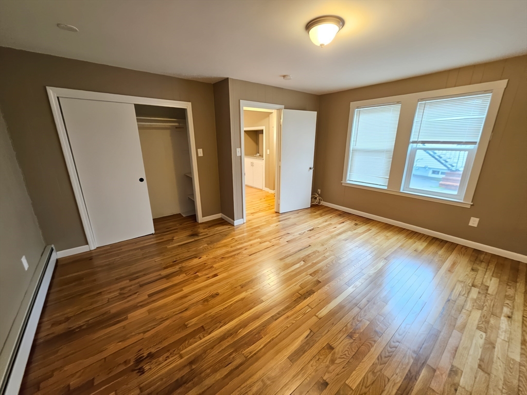 84 Cross Street Somerville, MA 02145 - Photo 19 of 42 a view of an empty room with wooden floor and a window