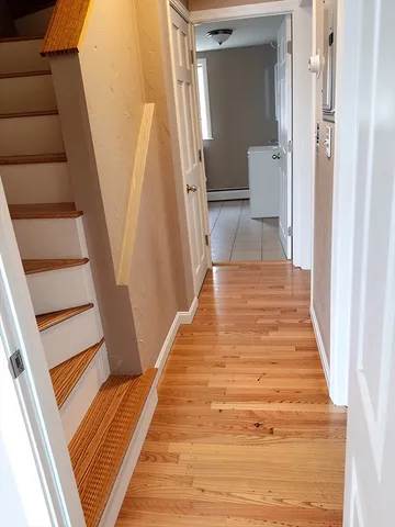a view of a hallway with wooden floor and staircase