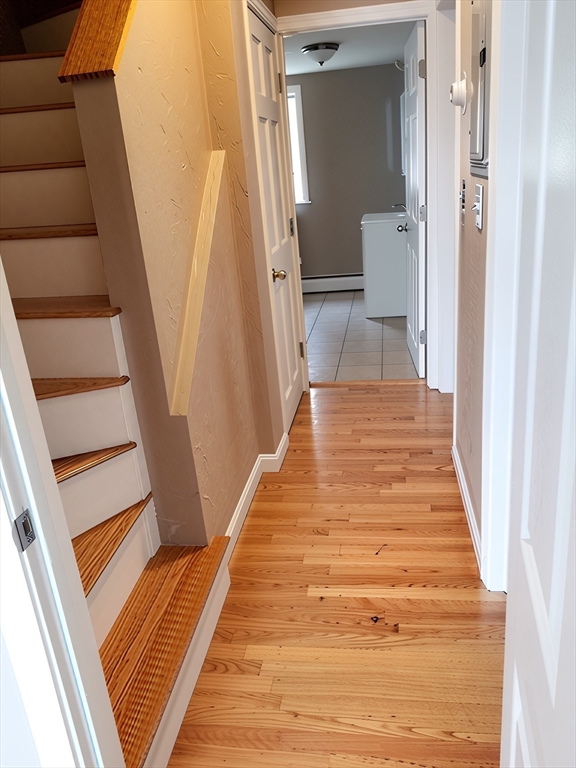 84 Cross Street Somerville, MA 02145 - Photo 26 of 42 a view of a hallway with wooden floor and staircase