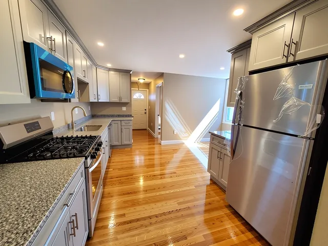 a kitchen with stainless steel appliances granite countertop a refrigerator stove top oven and sink