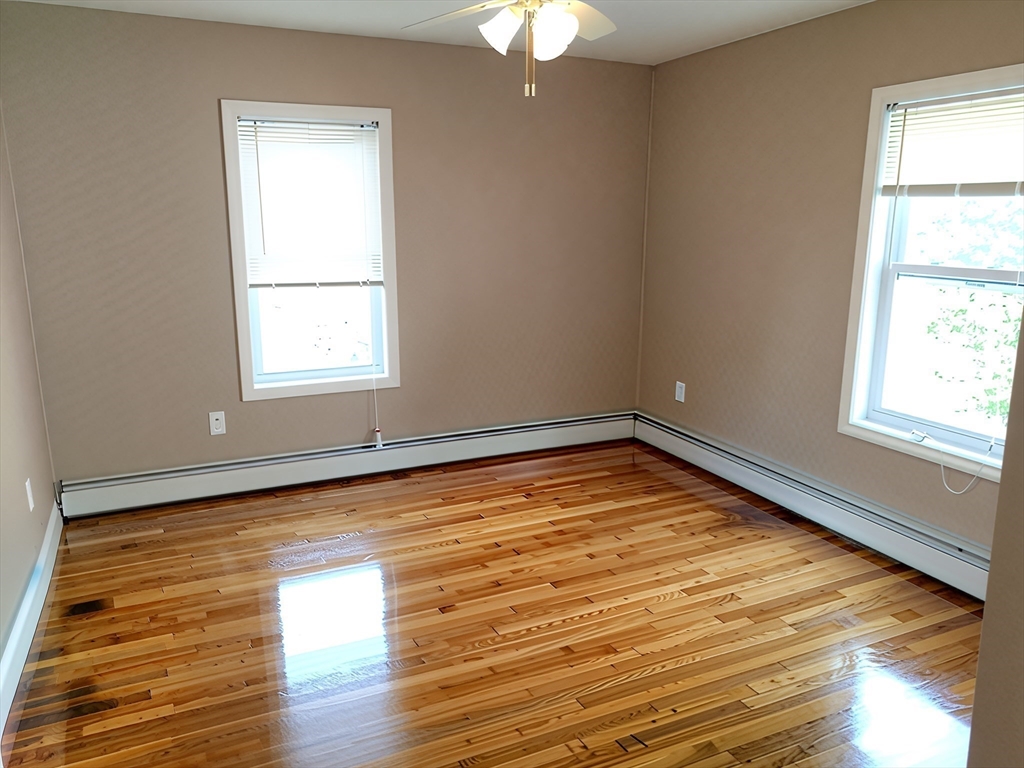 84 Cross Street Somerville, MA 02145 - Photo 33 of 42 a view of empty room with wooden floor and fan