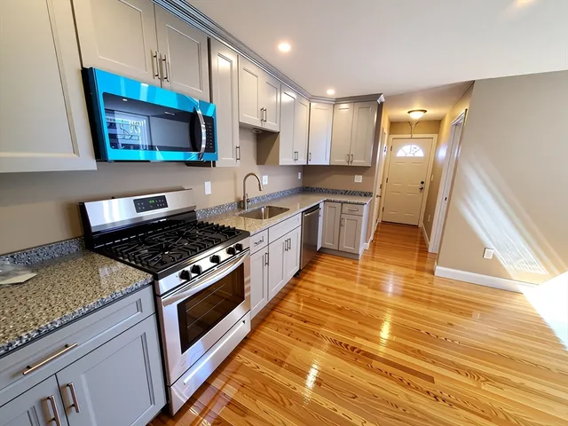 a kitchen with stainless steel appliances granite countertop a stove a sink and a microwave