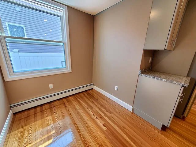 a kitchen with stainless steel appliances granite countertop a refrigerator a sink dishwasher a stove and a dining table with wooden floor