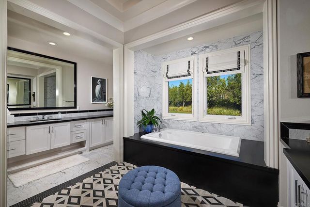a spacious bathroom with a double vanity sink a mirror and a bathtub