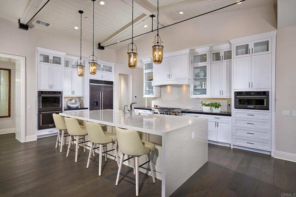 15527 Artesian Ridge San Diego, CA 92127 - Photo 6 of 25 a kitchen with stainless steel appliances kitchen island granite countertop a table chairs and a refrigerator