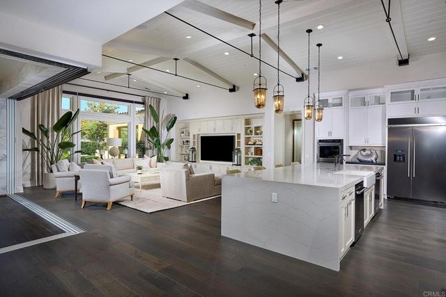 a living room with stainless steel appliances kitchen island furniture and a fireplace