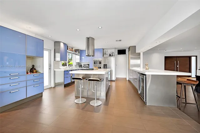 a kitchen with stainless steel appliances kitchen island granite countertop a sink stove and cabinets
