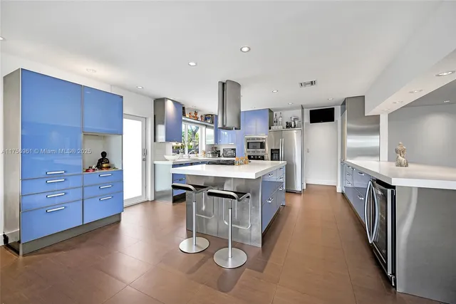 a kitchen with stainless steel appliances a sink cabinets and wooden floor