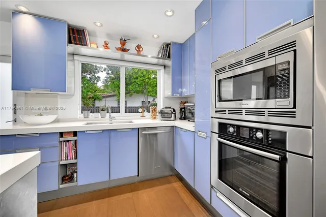 a kitchen with stainless steel appliances granite countertop a stove oven and a refrigerator with wooden floor
