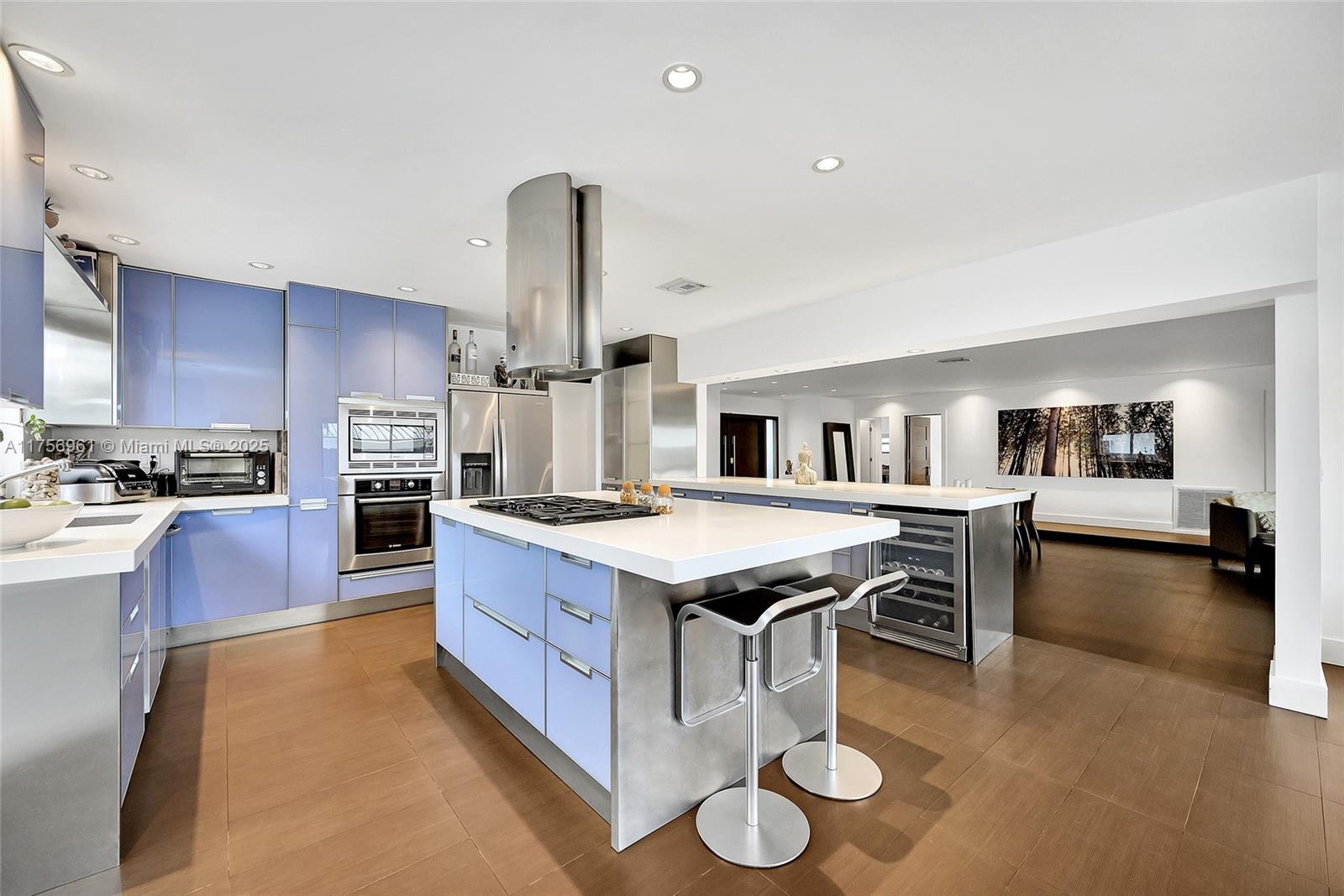 2120 Northeast 204th Street Miami, FL 33179 - Photo 21 of 52 a kitchen with stainless steel appliances granite countertop a stove oven and a refrigerator with wooden floor