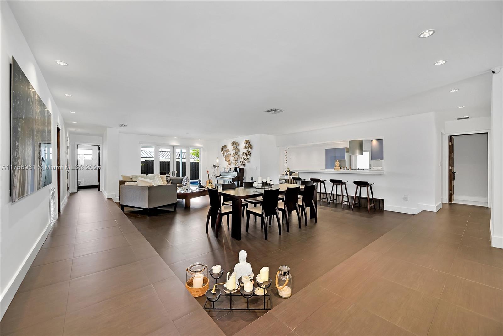 2120 Northeast 204th Street Miami, FL 33179 - Photo 8 of 52 a living room with furniture and a dining table with kitchen view