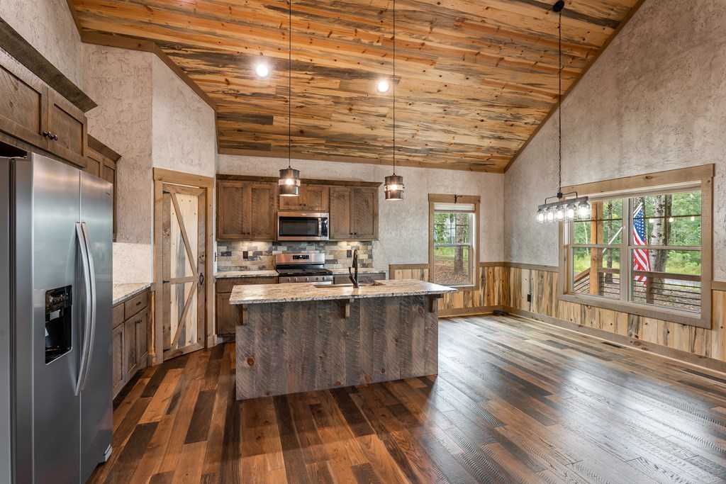 1450 Twisted Oak Road Talking Rock, GA 30175 - Photo 13 of 59 a kitchen with stainless steel appliances granite countertop a refrigerator a sink dishwasher a stove and white countertops with wooden floor