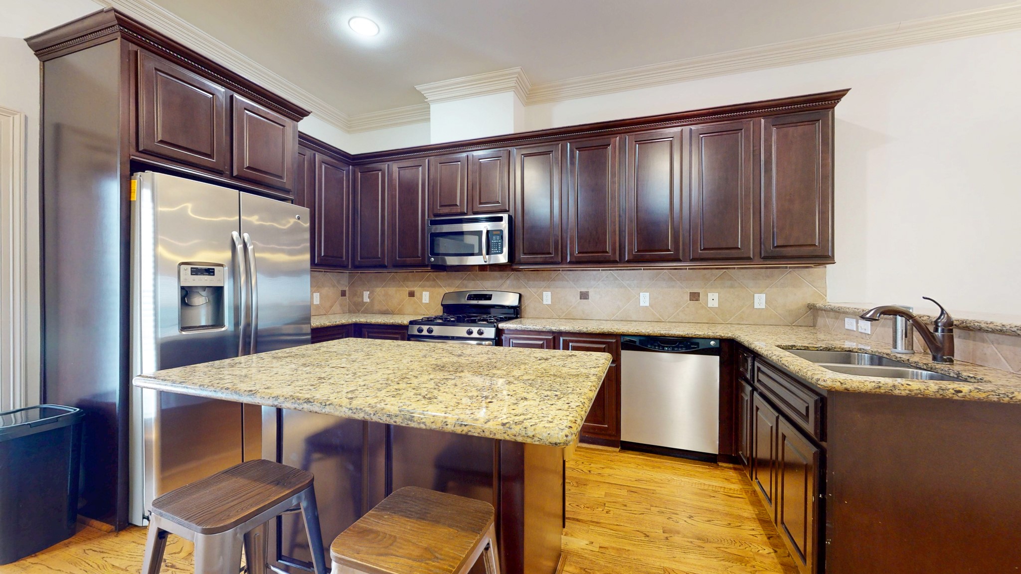 2540 Prospect Street, Unit B Houston, TX 77004 - Photo 4 of 18 a kitchen with stainless steel appliances granite countertop a table chairs sink refrigerator and cabinets