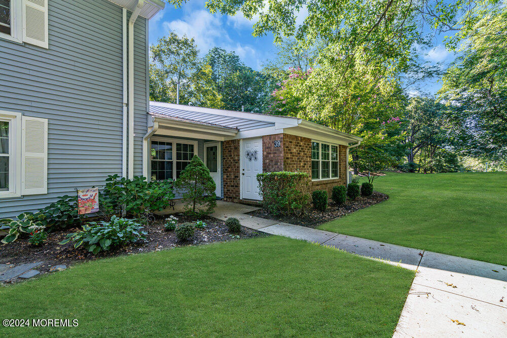 a view of house with a yard and potted plants