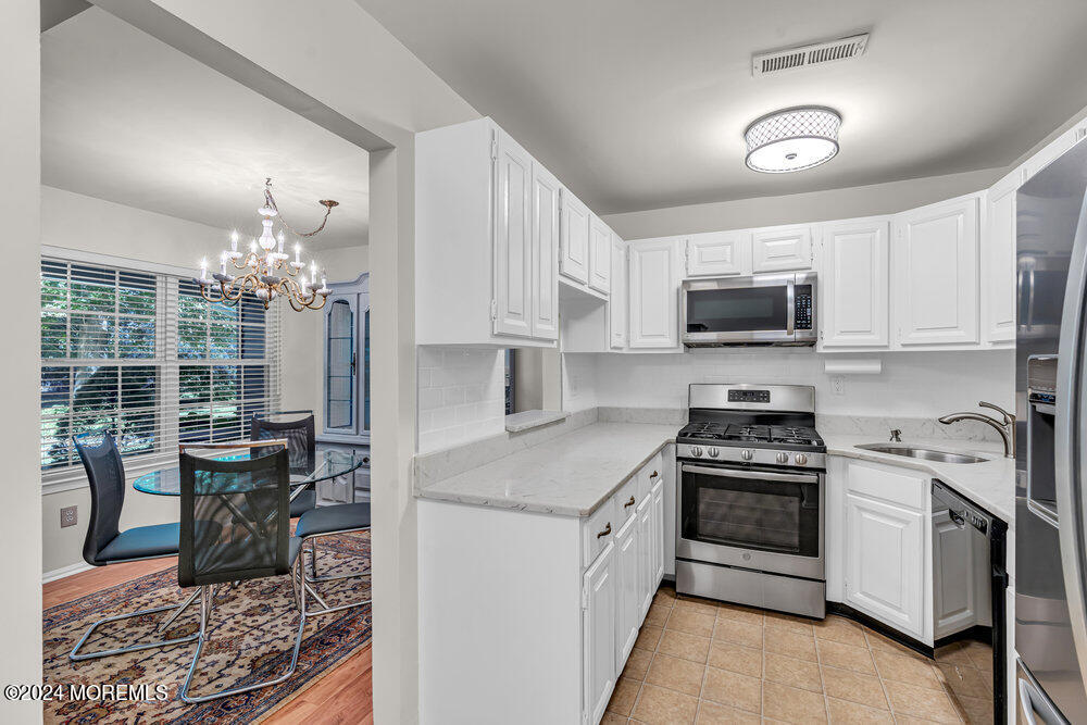 39 Firethorn Circle, Unit 339 Red Bank, NJ 07701 - Photo 5 of 16 a kitchen with a stove a sink and a microwave