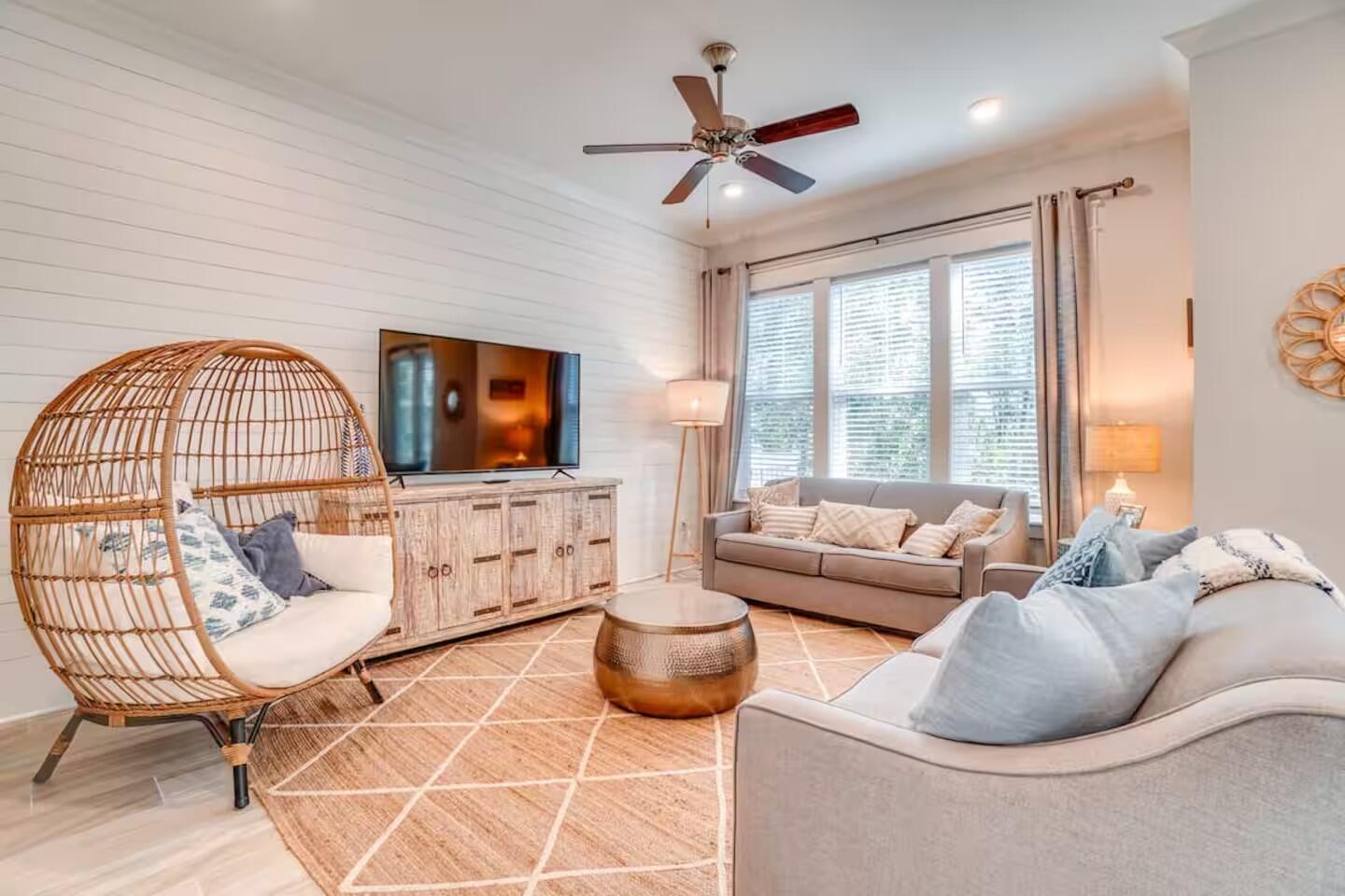 a living room with furniture a flat screen tv and a large window