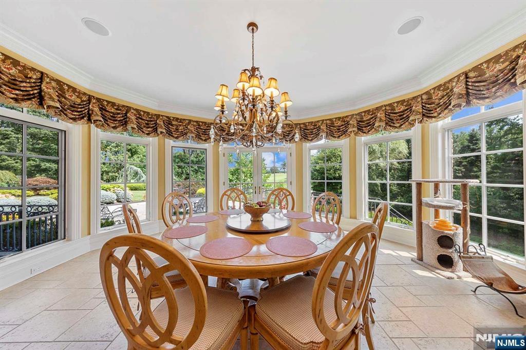 196 Vaccaro Drive Alpine, NJ 07620 - Photo 28 of 50 a dining room with furniture large windows and a chandelier