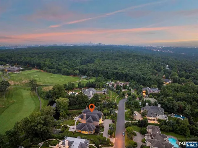an aerial view of a house with a garden and lake view