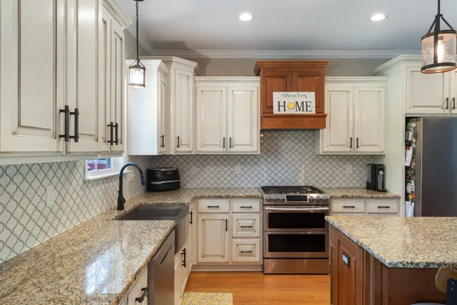 a kitchen with kitchen island granite countertop a stove and a sink