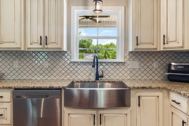 a open kitchen with stainless steel appliances granite countertop a stove top oven a refrigerator a dining table and chairs with wooden floor