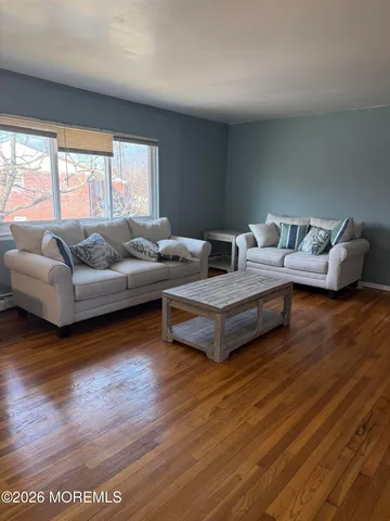 a living room with furniture and a wooden floor