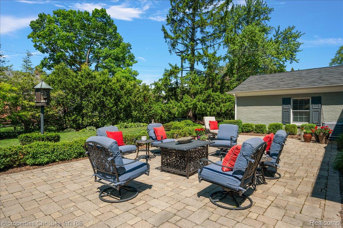 135 Clifton Road Bloomfield Hills, MI 48301 - Photo 71 of 77 Expansive paver patio bordered by manicured hedges and a lush lawn