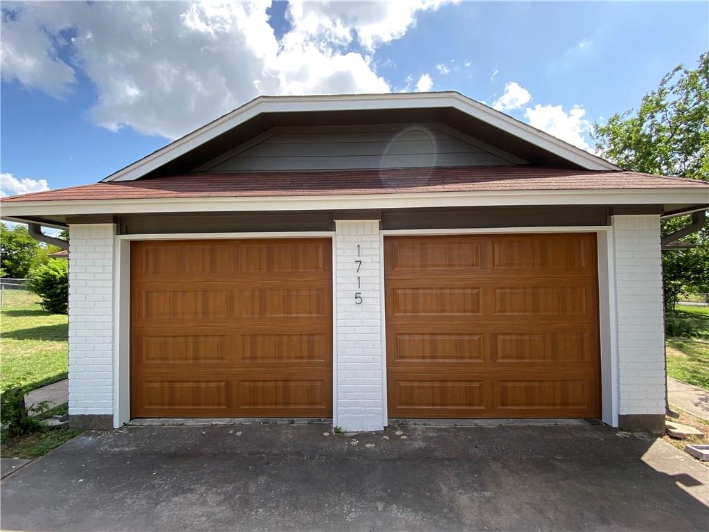 1715 Shadowview Drive, Unit B Austin, TX 78758 - Photo 3 of 28 A well-maintained two-car garage offers ample parking and storage, featuring durable brick construction.