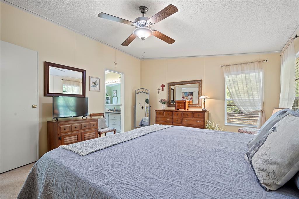 159 Southwest 70th Avenue Bell, FL 32619 - Photo 12 of 42 a bedroom with a large bed and a chandelier