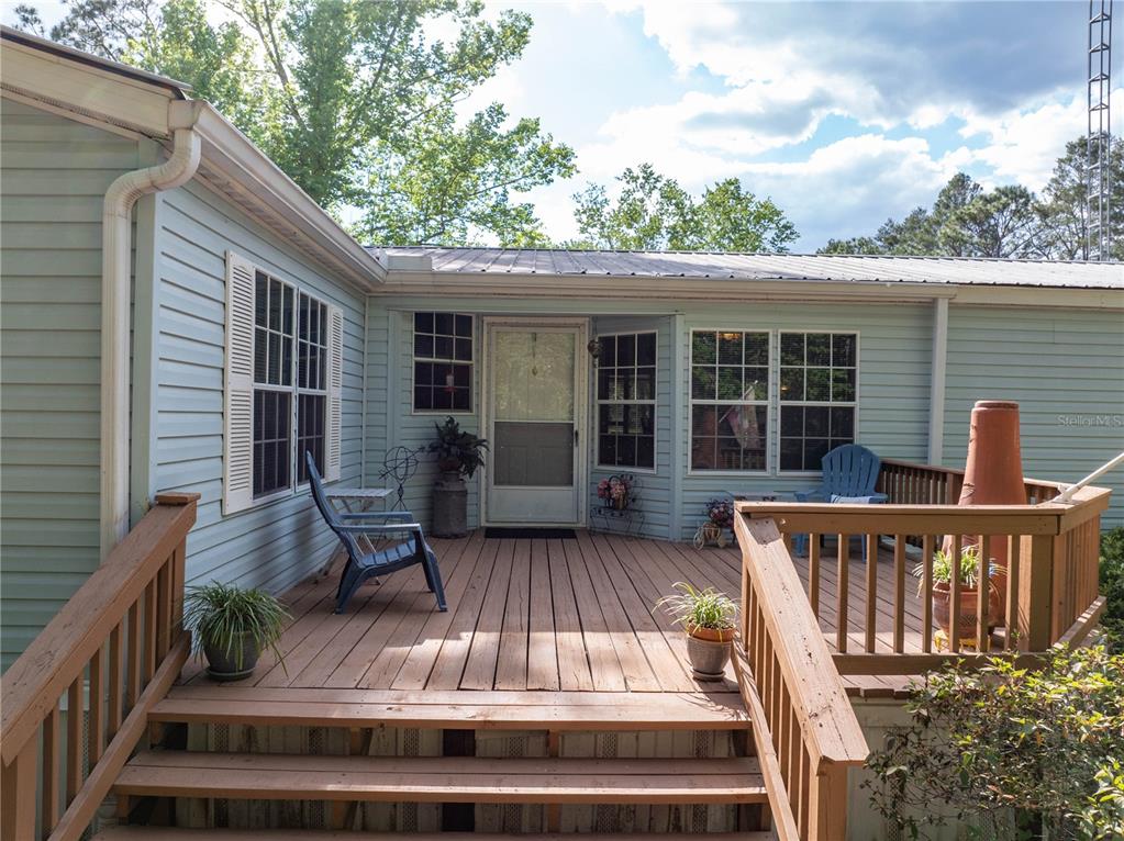 159 Southwest 70th Avenue Bell, FL 32619 - Photo 23 of 42 a view of a house with wooden deck and furniture