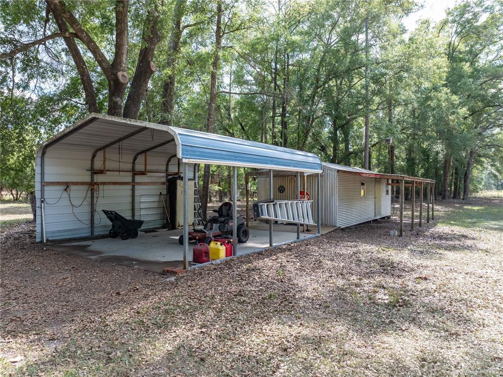 159 Southwest 70th Avenue Bell, FL 32619 - Photo 25 of 42 a view of a small house with large trees and wooden fence