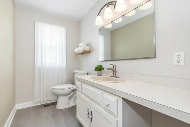 a bathroom with a toilet sink and mirror