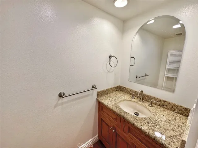 a bathroom with a granite countertop sink a mirror and shower