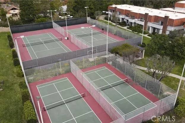a view of a tennis ground with large trees