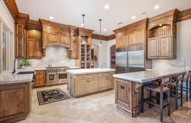 a kitchen with stainless steel appliances granite countertop a stove a sink and a refrigerator