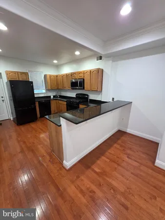 a kitchen with stainless steel appliances kitchen island granite countertop a sink and a microwave