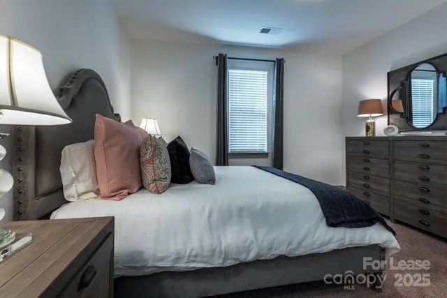 a bedroom with a bed and dresser with mirror