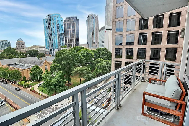 a living room with furniture large window and wooden floor
