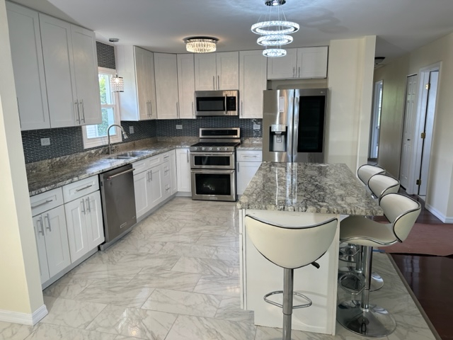 277 Armstrong Drive Buffalo Grove, IL 60089 - Photo 4 of 19 a kitchen with stainless steel appliances granite countertop a stove refrigerator and a sink