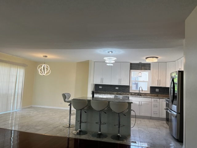 277 Armstrong Drive Buffalo Grove, IL 60089 - Photo 6 of 19 a kitchen with stainless steel appliances a stove a sink refrigerator and cabinets