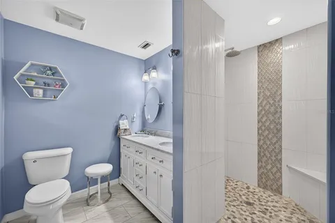 a bathroom with a toilet a sink a shower and a mirror