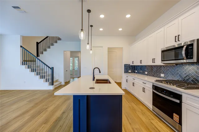a kitchen with a sink appliances and cabinets