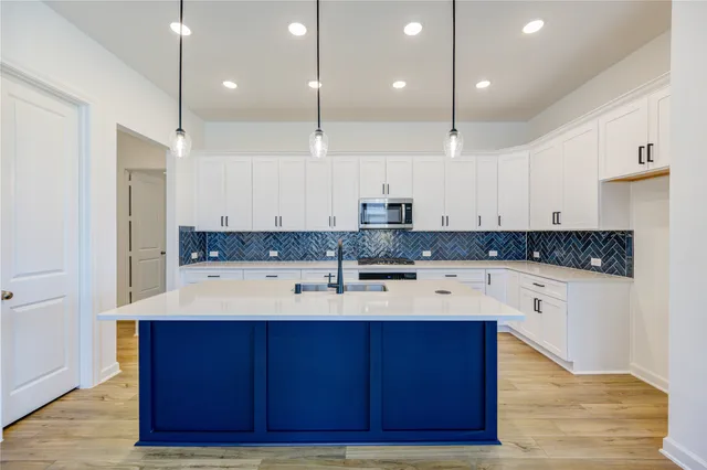 a kitchen with a sink cabinets and wooden floor