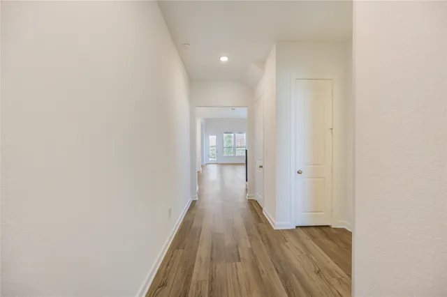 a view of a hallway with wooden floor