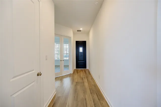 a view of a hallway with wooden floor and staircase