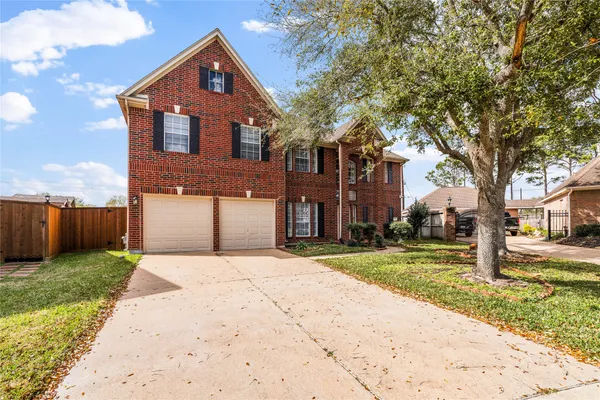 a front view of a house with a yard and trees