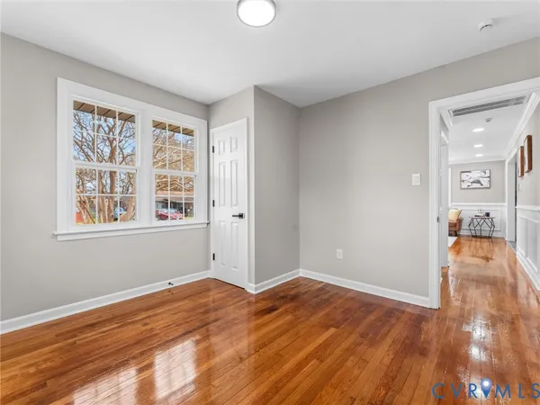 a view of empty room with wooden floor