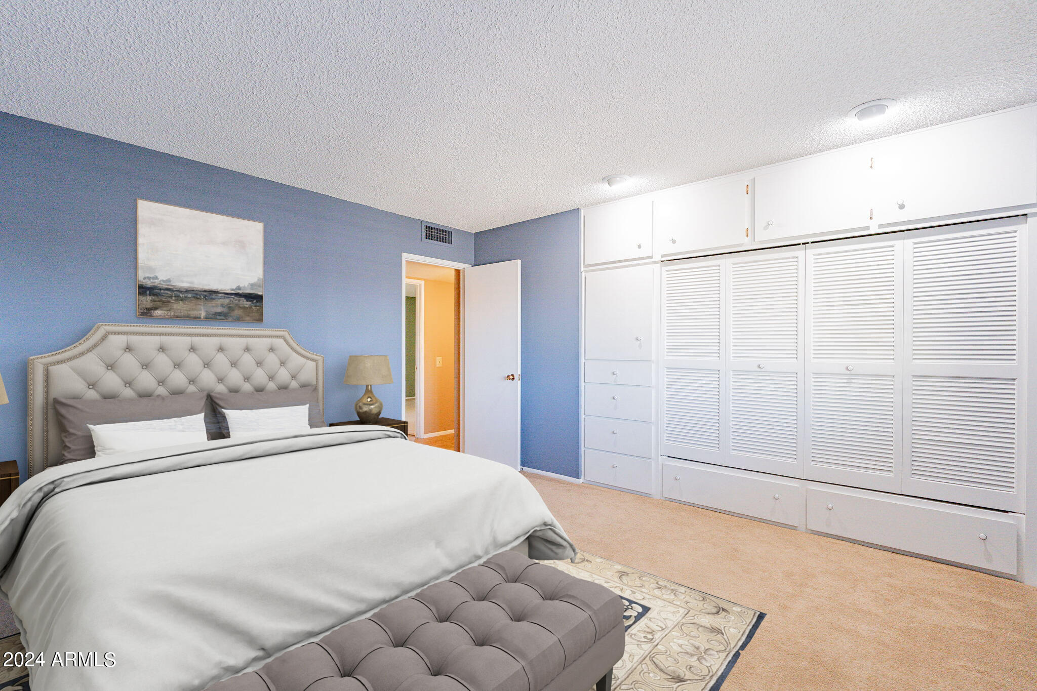9510 West Greenway Road Sun City, AZ 85351 - Photo 19 of 46 a bedroom with a large bed and a shower